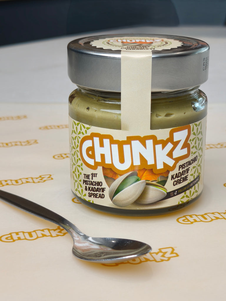 Jar of Chunkz pesto spread on a branded surface with a spoon beside it.